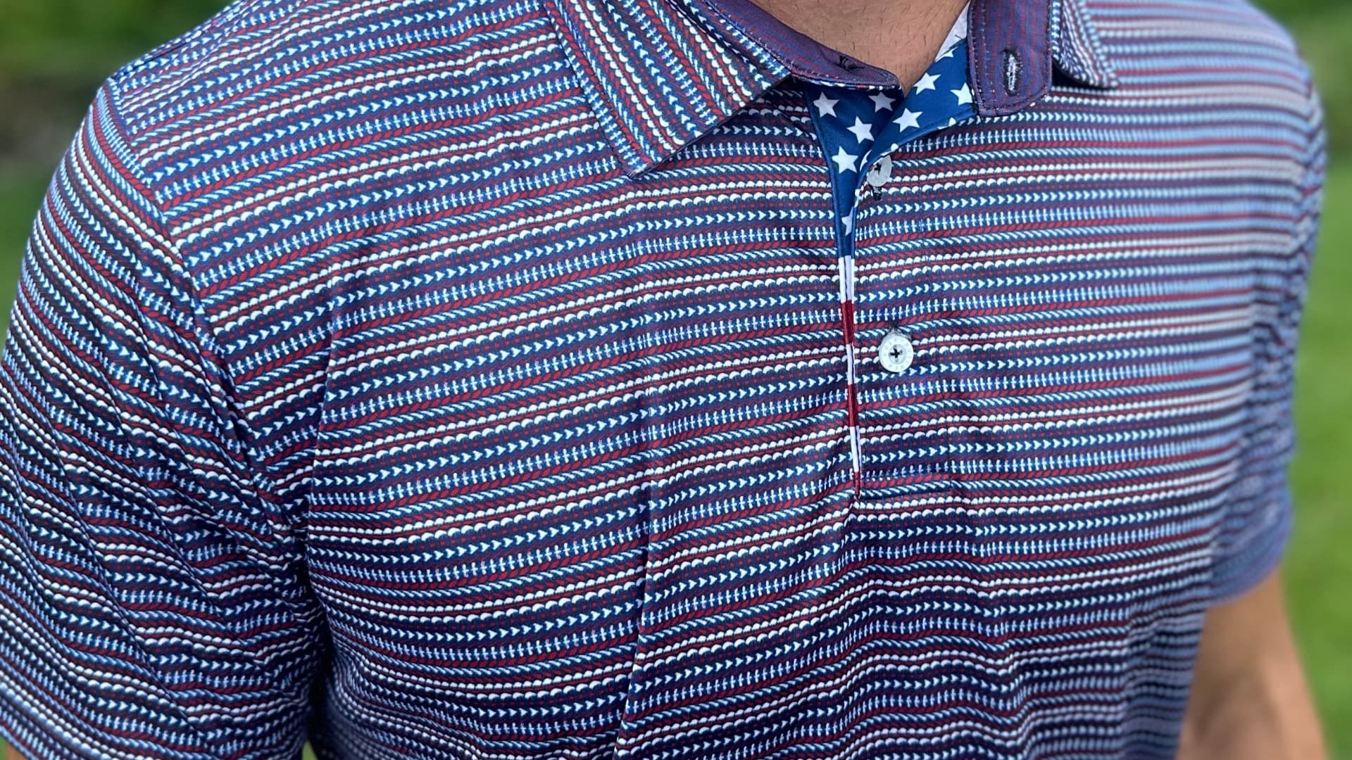 Custom corporate polo with a tonal brand pattern and clean chest logo, photographed to show detail at close range.